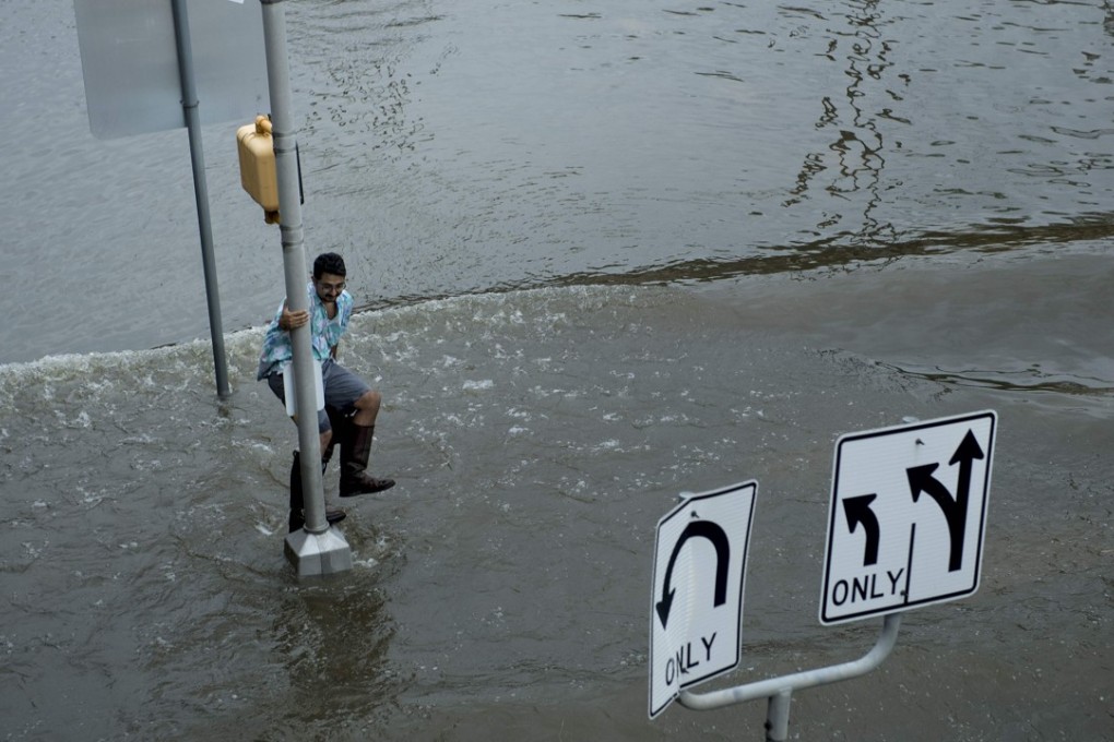 A man dodges a wake in flood waters during the aftermath of Hurricane Harvey in Houston, Texas, on Sunday. Photo: AFP