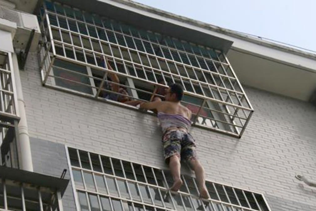 The neighbour cradles the girl in his arms as he waits for help to arrive. Photo: Handout