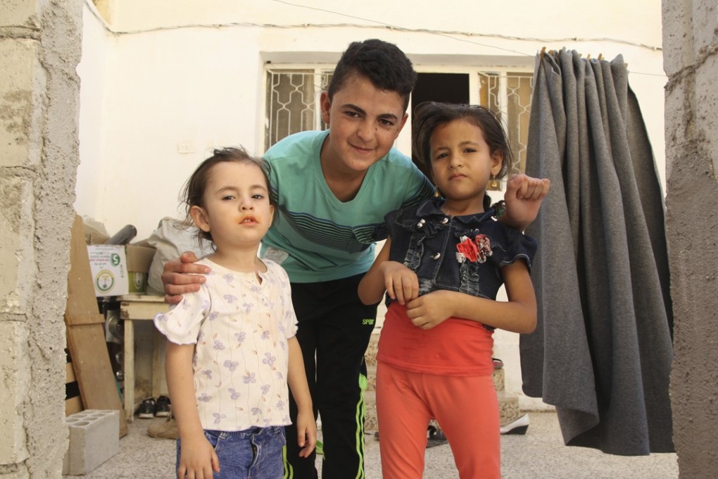 In this July 31 photo, 15-year-old Syrian refugee Ali al-Sbehi, centre, poses on with his little sister Tuqqa, left, and his cousin Aseel in Manshiyeh, northern Jordan. Photo: AP