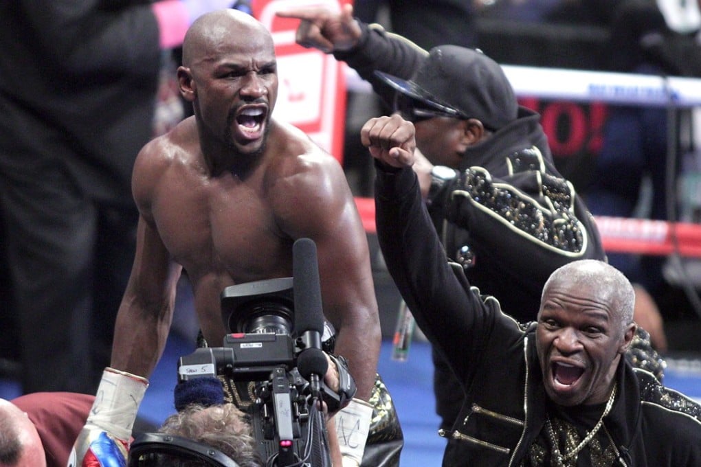 Floyd Mayweather Jnr (right) celebrates with his father after his 10th-round TKO victory over Conor McGregor. Photo: AFP
