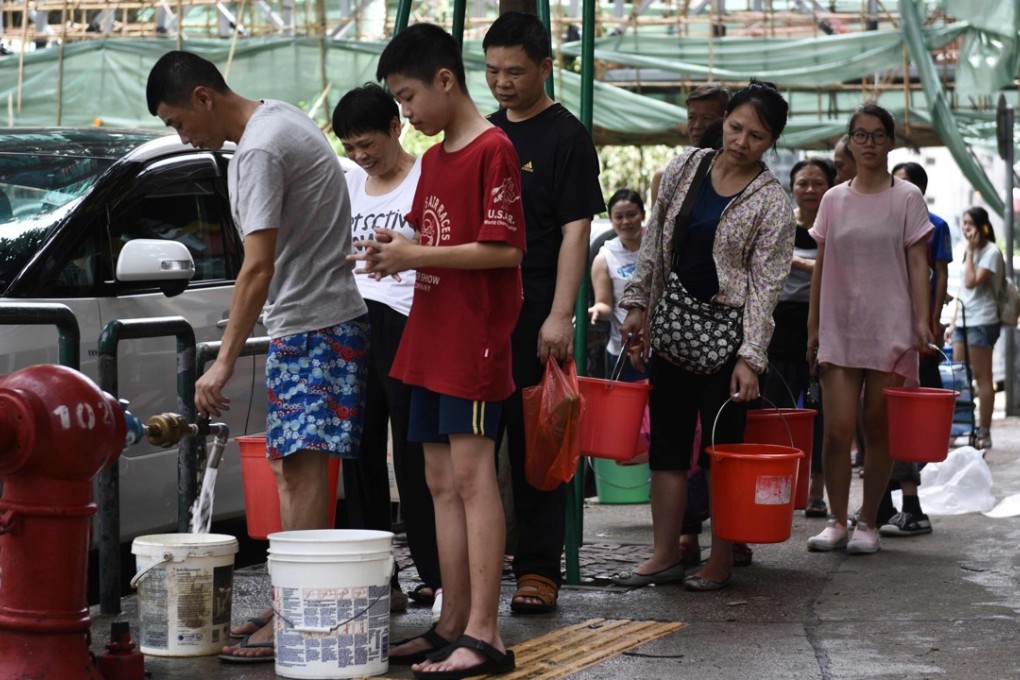 People queue up to collect water from a fire hydrant in Macau on August 24, a day after Typhoon Hato left a trail of destruction, with water supplies badly hit. Photo: AFP