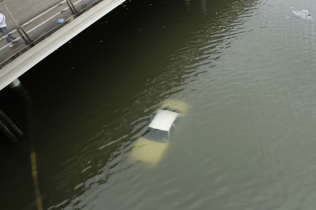 People look at submerged cars on a Houston freeway flooded by Tropical Storm Harvey on Sunday. Photo: AP