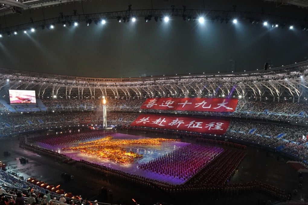 Spectators watch performers dance on stage with huge red banners declaring "Welcome the 19th party congress, go to a new journey together" during the opening ceremony of the National Games in Tianjin on Sunday. Photo: AP