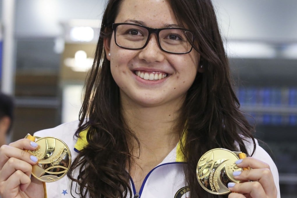 Siobhan Haughey shows her two gold medals at Hong Kong International Airport on Sunday night after returning from the World University Games in Taiwan. Photo: Dickson Lee