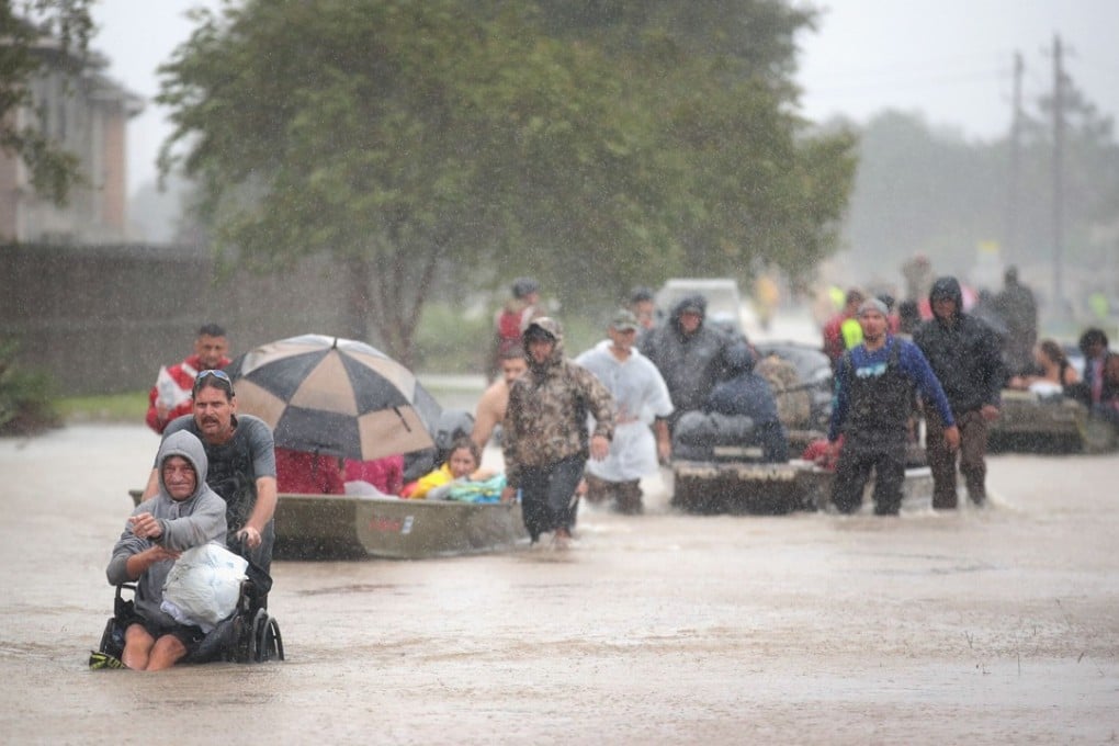 Rain teems down as evacuees are rescued from a flooded neighbourhood in Houston, Texas, on Monday. Photo: AFP