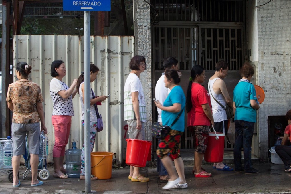 People queue to collect water from a public water tab after water pipes have been broken by Typhoon Hato in Macau. Photo: EPA
