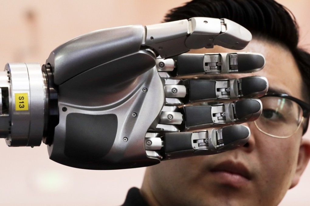 A visitor looks at a robotic hand on display at the World Robot Conference in Beijing on August 23. Policymakers must ensure they keep their focus on what it really means to be a smart city. Photo: AP
