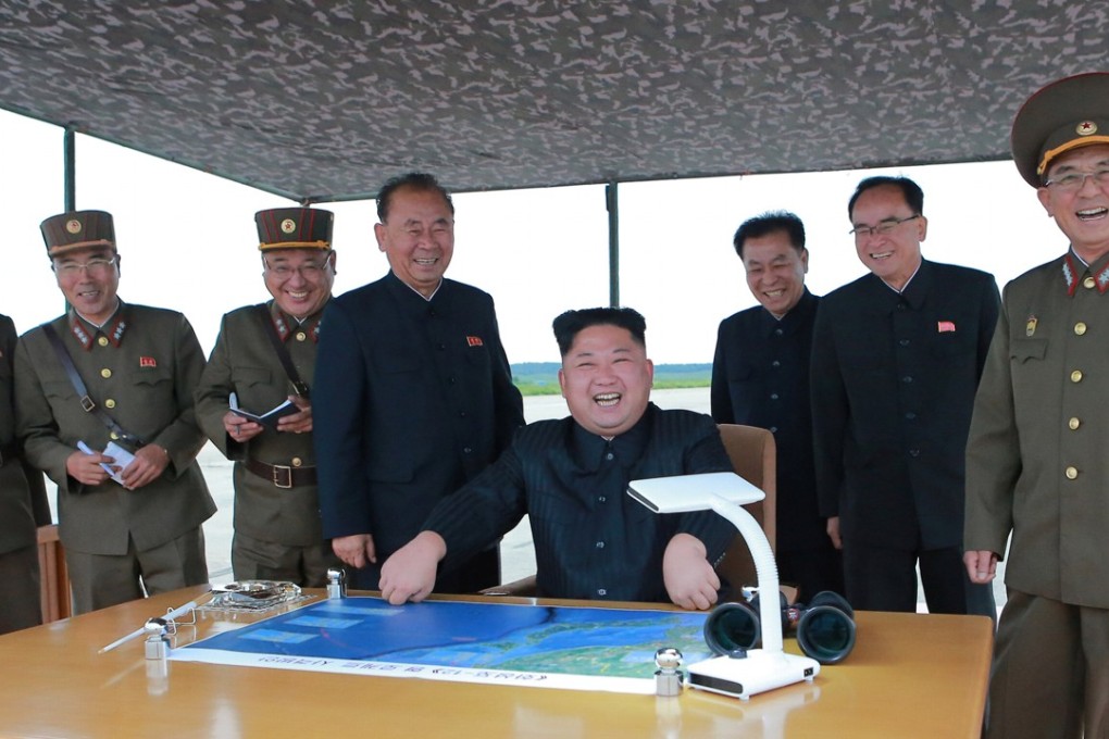 North Korean leader Kim Jong-un and his generals laugh after watching the launch of a ballistic missile on Tuesday that flew over Japan. The launch reportedly took place from Pyongyang’s airport. Photo: Reuters