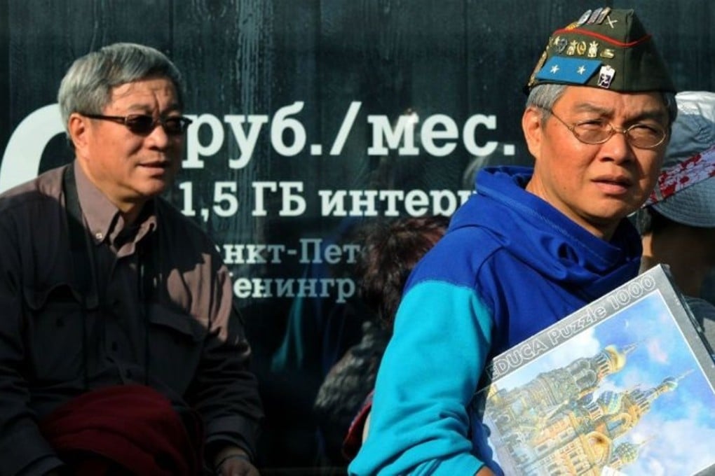 Chinese tourists wear Russian memorabilia in St Petersburg, Russia. Photo: AFP
