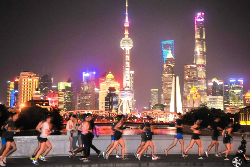 Joggers out at night in Shanghai. It, like Hong Kong, is an international metropolis that needs talented people. Photo: AFP