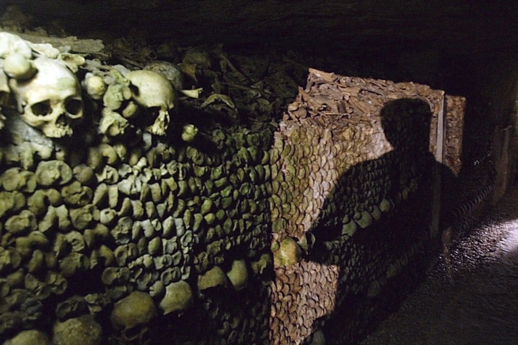 A man walks through the bone-filled catacombs of Paris. Photo: AP