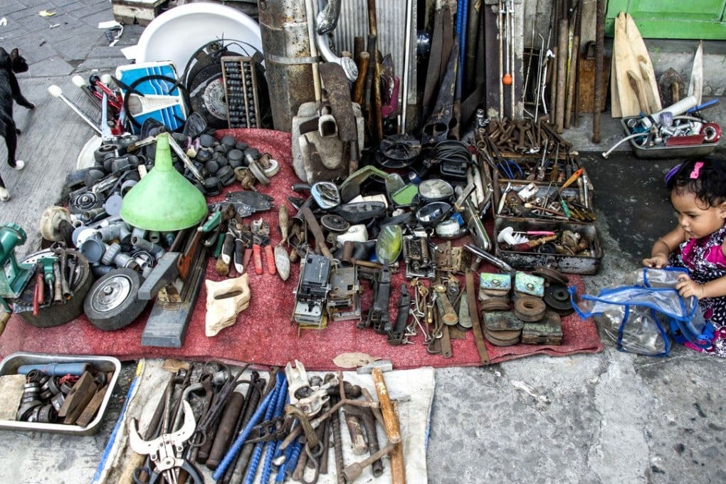 An Indonesian child plays at a street stall on one of the country’s infamously crowded pavements. Photo: AFP