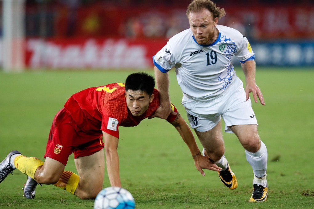 China’s Deng Hanwen stumbles to the ground as Uzbekistan’s Vitaliy Denisov chases the ball. Photo: Reuters