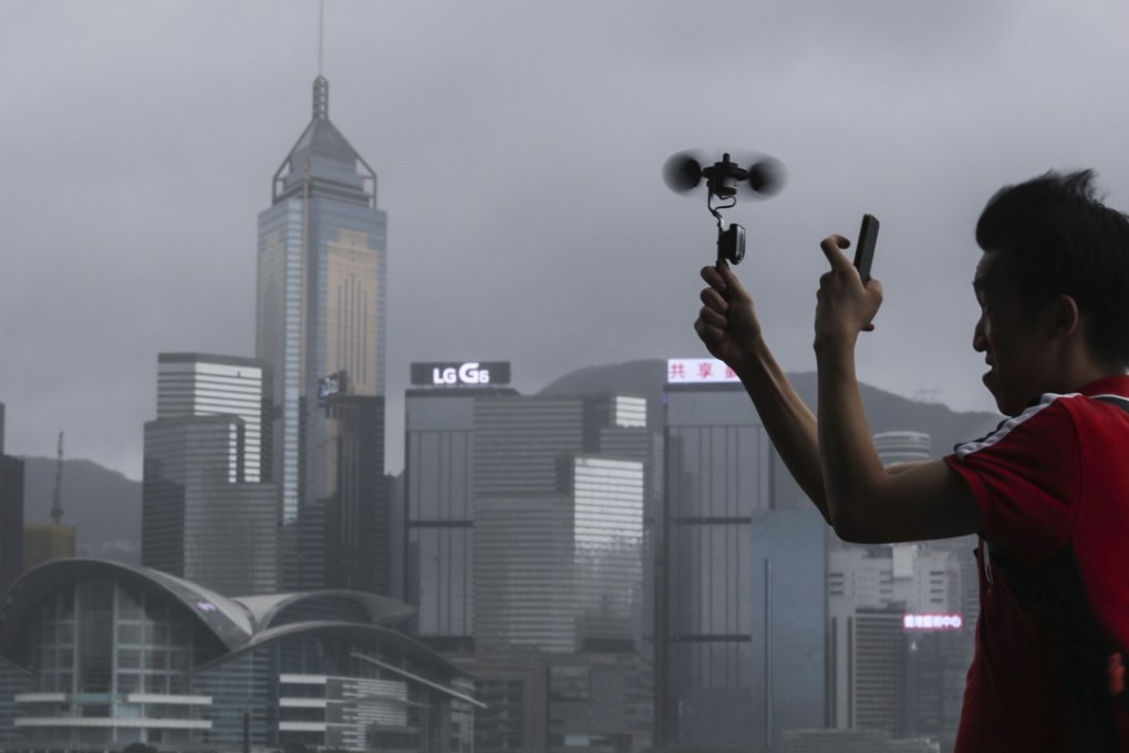 A man checks the wind speed in Tsim Sha Tsui as Pakhar hits Hong Kong on August 27. Photo: Felix Wong