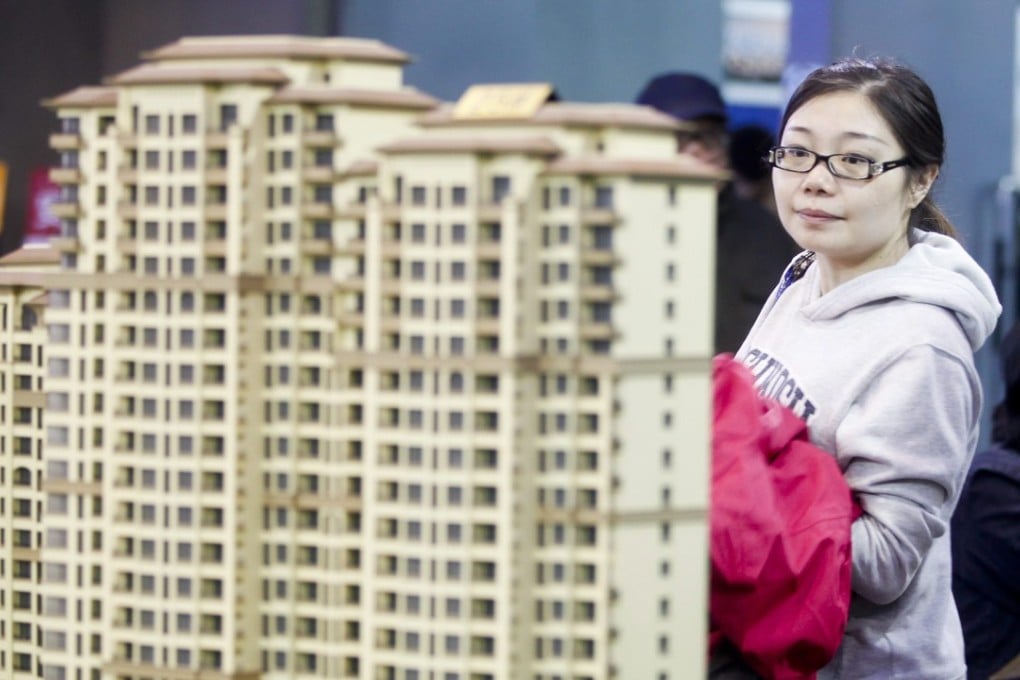 Potential buyers look at models of new residential developments for sale in Beijing. China’s big four state-owned banks significantly slowed their lending pace in the first half of this year. Photo: EPA