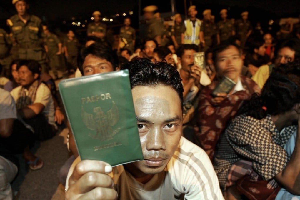 An Indonesian migrant worker in Kuala Lumpur shows his passport during a late-night immigration raid. Photo: AFP