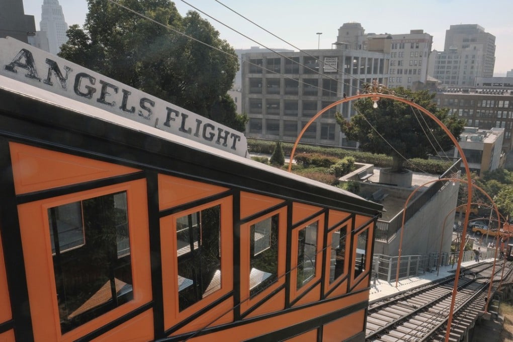 A pedestrian walks a steep flight of stairs next to the Angels Flight railroad in downtown Los Angeles. The 298-foot funicular, closed since a 2013 derailment, reopened on Thursday, August 31, just in time to ferry thousands of holiday weekend visitors up and down downtown's steep Bunker Hill, something it first did on New Year's Eve 1901. Photo: AP