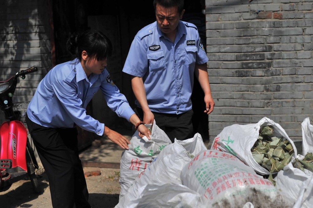Officials seize bags of rice dumplings made from contaminated rice and containing an illegal artificial sweetener, at an unlicensed workshop in Beijing. Photo: AFP