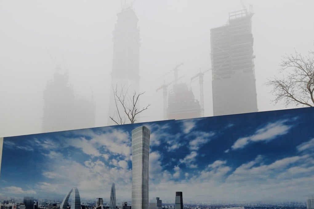 A construction site hoarding featuring a blue sky contrasts with smog in Beijing in December last year. Photo: AP