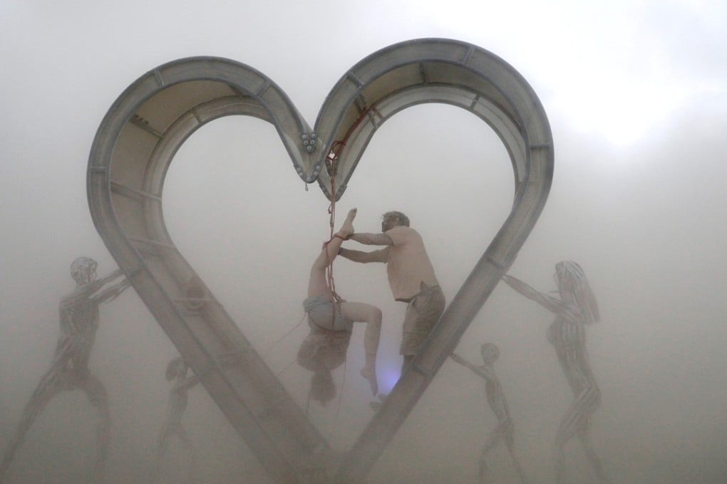 Burning Man participants perform a shibari rope scene during a driving desert dust storm inside the heart of the ‘Identity Awareness – Family’ art project created by artist Shane Pitzer. Photo: Reuters