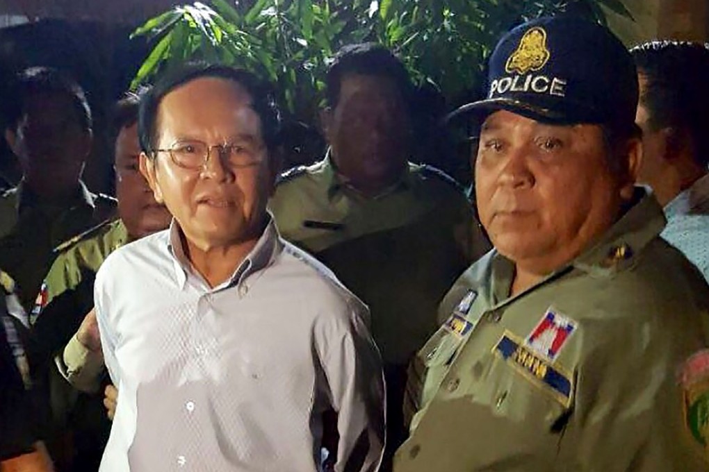 Cambodian opposition leader Kem Sokha (L) is escorted by police at his home in Phnom Penh. Photo: AFP