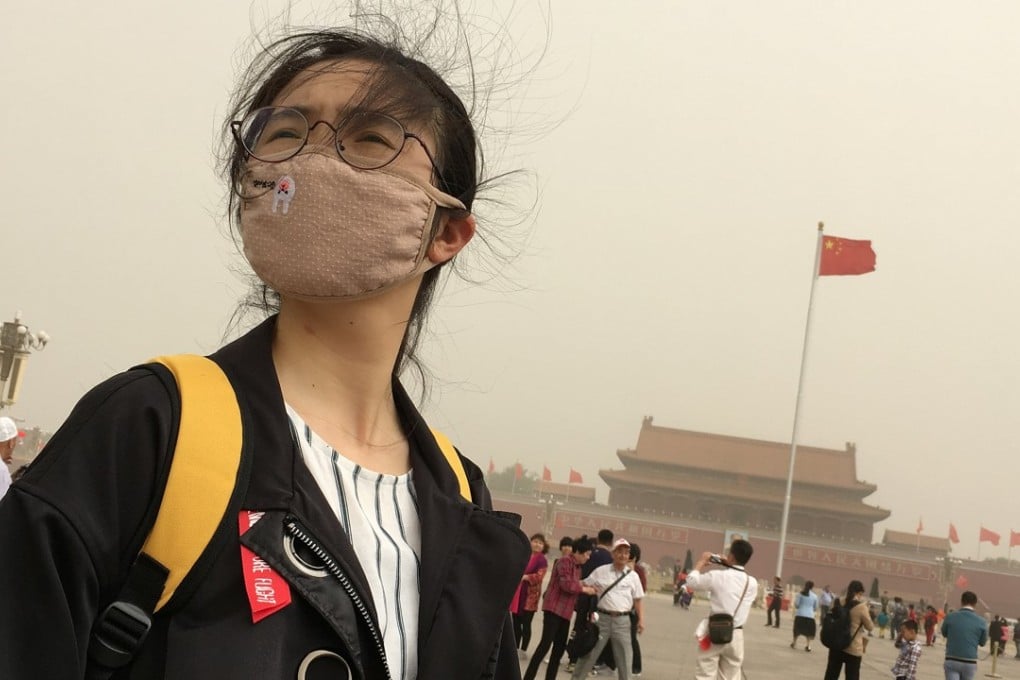 A woman wears a face mask in Tiananmen Square as a sandstorm hits Beijing in May. Photo: Reuters