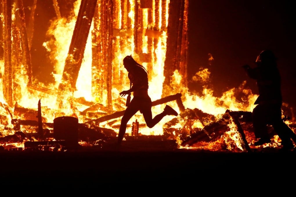 Aaron Joel Mitchell, 41, evades a chasing firefighter and runs into the flames of the “Man Burn” bonfire at the annual Burning Man arts and music festival in the Black Rock Desert of Nevada, on Saturday night. Mitchell died after being engulfed by the flames. Photo: Reuters