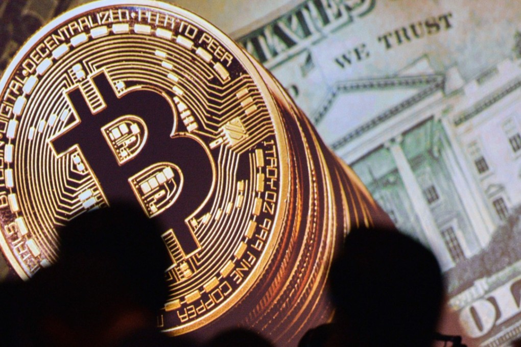 Bitcoin and the US currency are displayed on a screen as delegates listen to a panel during the Interpol World Congress in Singapore on July 4. The price of bitcoin versus the US dollar has gone up over 330 times. Photo: AFP