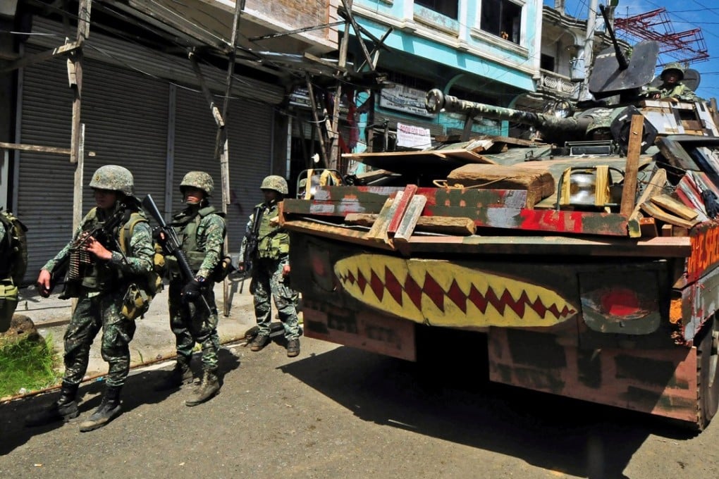 An armoured car and soldiers march towards Mapandi bridge in Marawi. Photo: Reuters