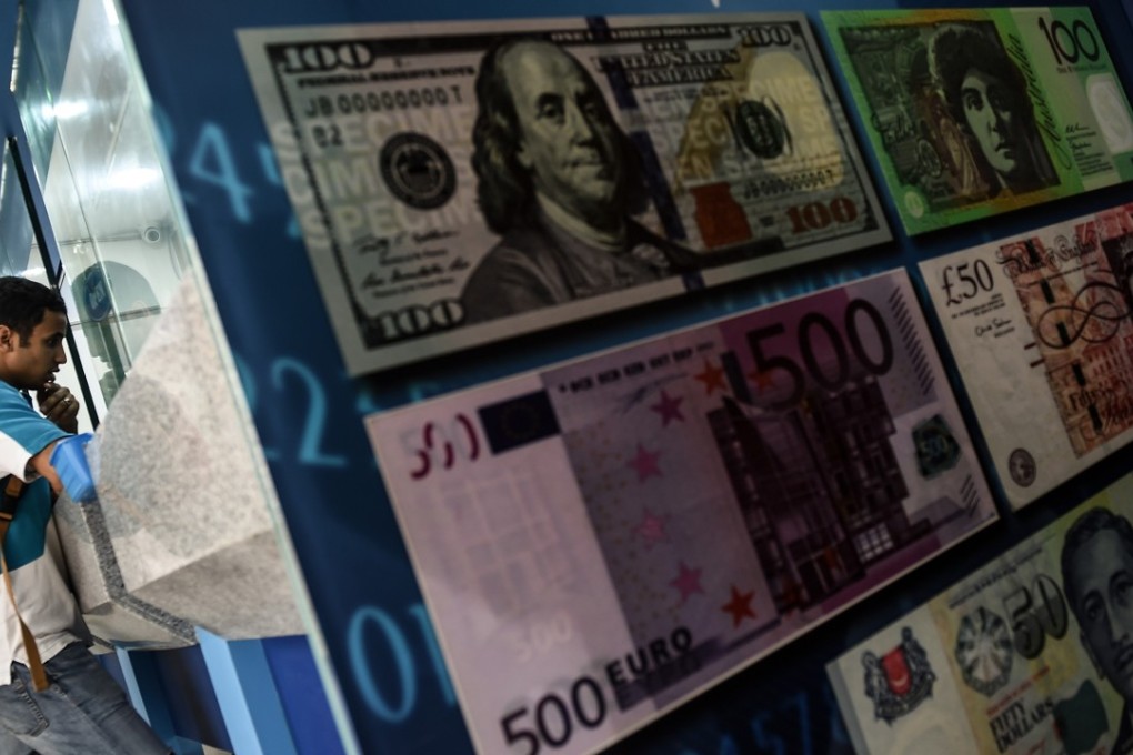 A foreign tourist inquires about exchange rates on the Malaysian ringgit at a foreign currency money-changer in Kuala Lumpur. Photo: AFP/MANAN VATSYAYANA