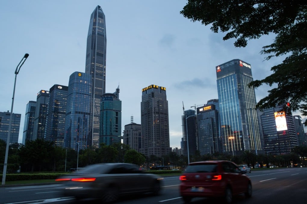 Cars drive past commercial buildings in Shenzhen’s business district in June. Photo: EPA