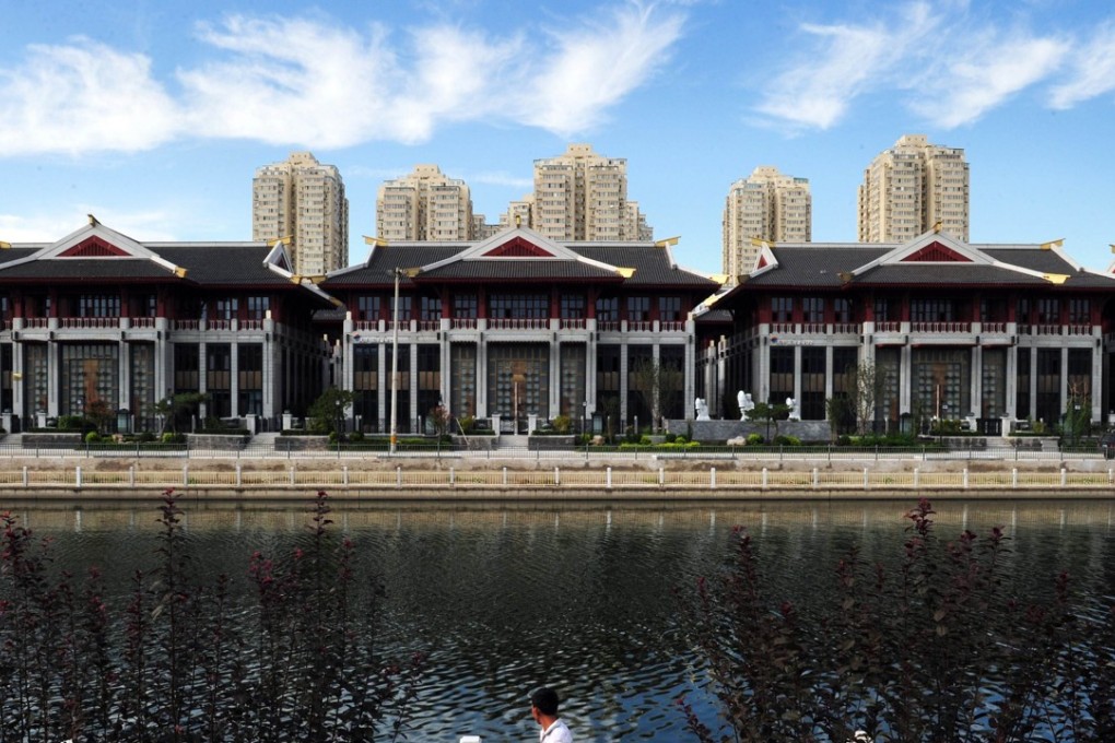 Expensive lakeside villas stand in front of public housing in the Chaoyang District of Beijing. Builders have been warned they won’t be granted pre-sale permits if they separate affordable from luxury housing in the same development. Photo: AFP