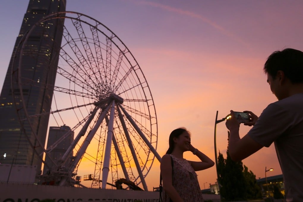 Tourists take snaps in front of the Hong Kong Observation Wheel. Photo: K. Y. Cheng