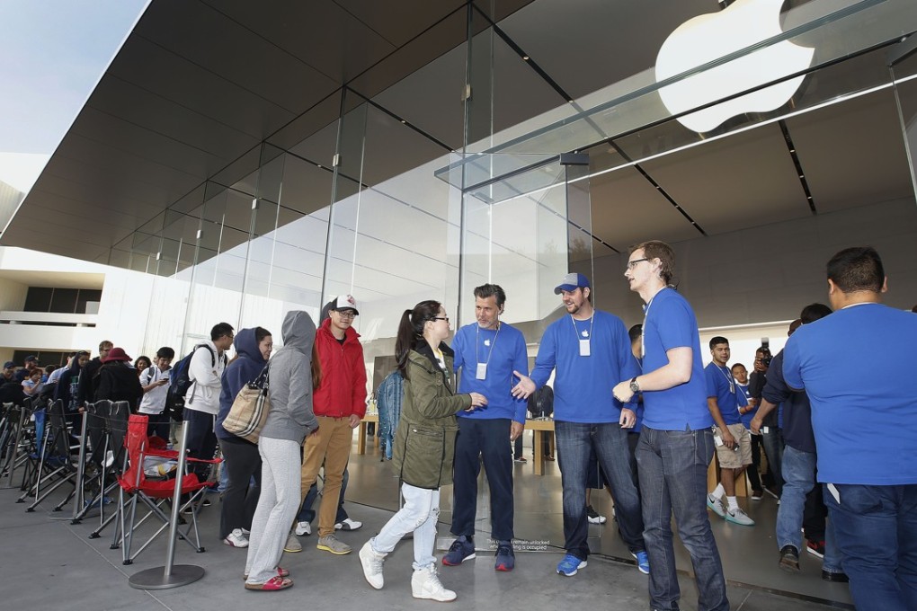 Apple employees greet the first customers in line at an Apple Store for the launch and sale of the new iPhone 6 in September 2014 – the last time Hong Kong’s incumbent operators recorded significantly high handset sales as a result of an Apple launch. Photo: AP