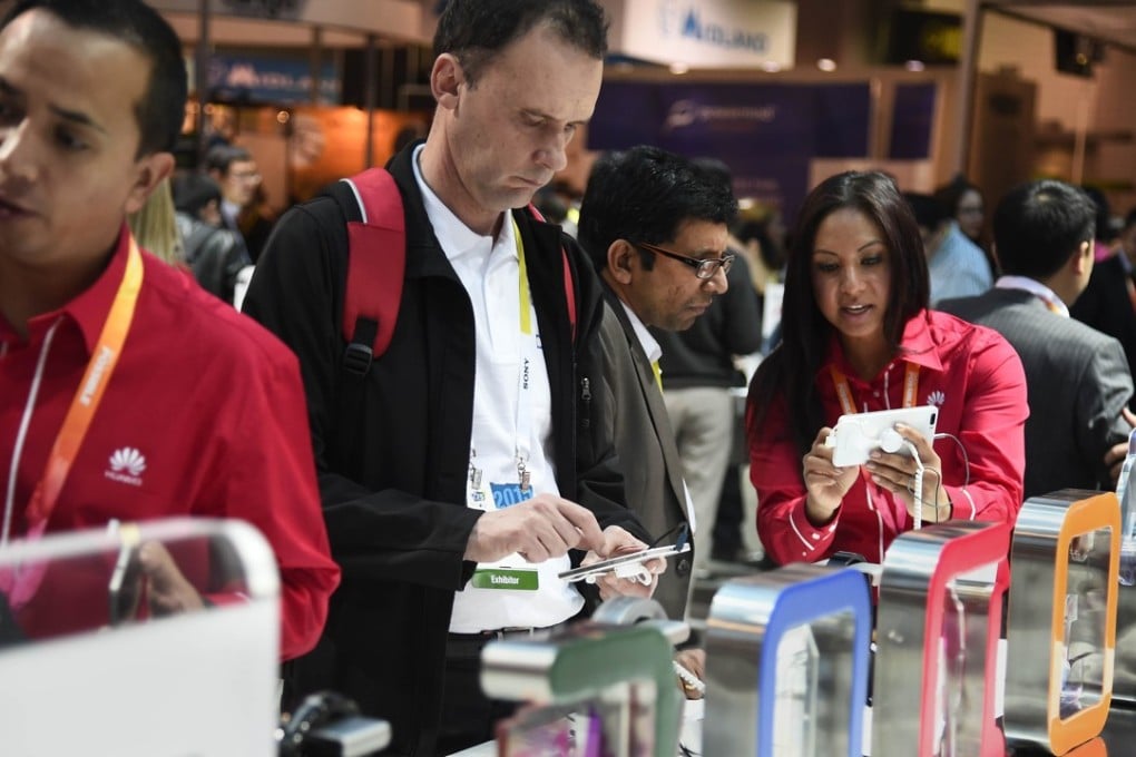 Customers try out Huawei Honor 6 Plus and Honor P7 smartphones. Photo: AFP