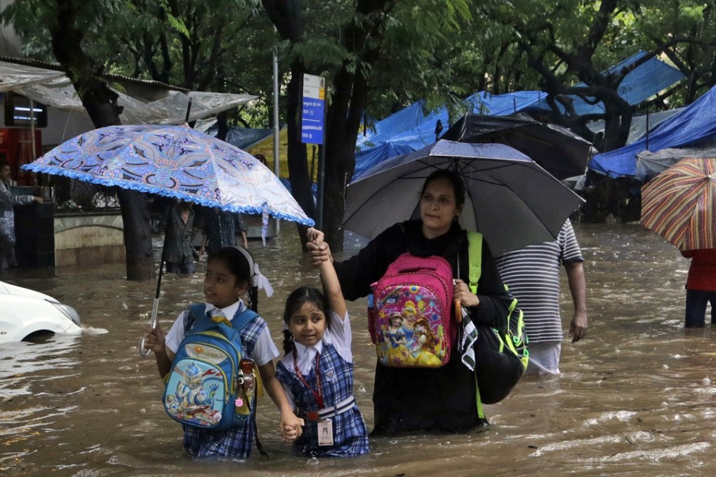 Families wade through floods in Mumbai on August 29. Mumbai was especially hard hit, with water swamping offices, schools and roads, and some 60 people killed. Photo: AP