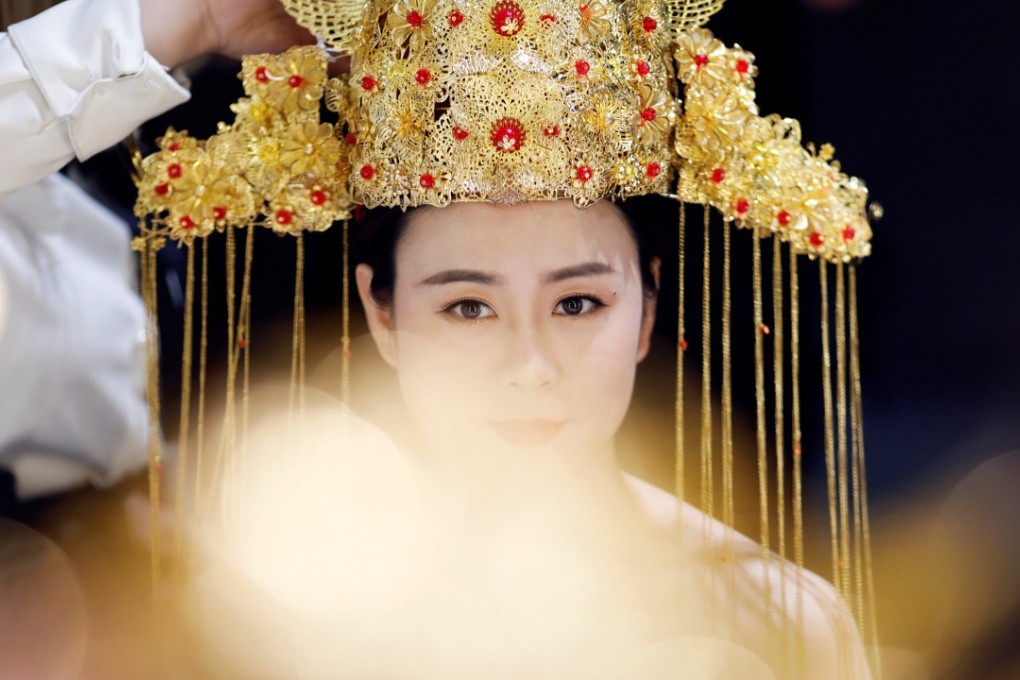 A woman is dressed and made up before having photographs taken at the Golden Ladies wedding photography studio in Beijing. Photo: Reuters
