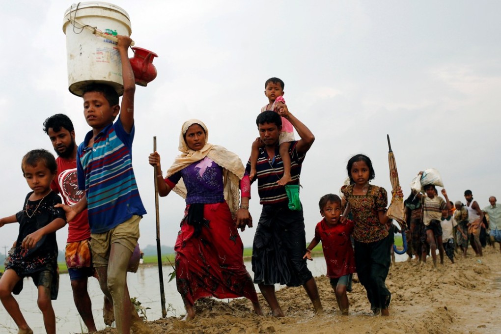 Rohingya refugees walk on a muddy path after crossing the Bangladesh-Myanmar border. Photo: Reuters