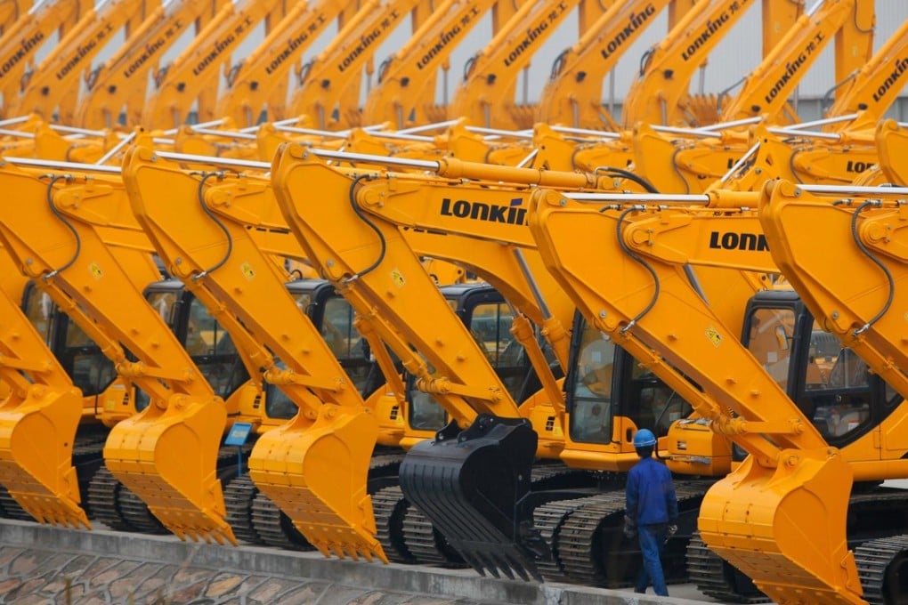 A man walks past a line of new excavators at a Lonking factory in Shanghai in this file photograph. Sales of excavators in the first eight months of 2017 more than doubled from the same period of the previous year. Photo: Reuters