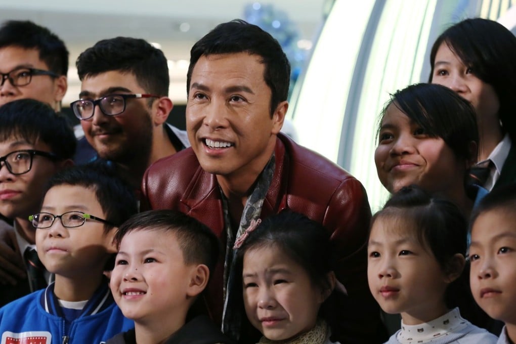 Actor Donnie Yen Ji-dan (centre) and fans pose for a photo at the premiere of Rogue One: A Star Wars Story, in Mong Kok last December. The Chicken Soup Foundation treated 300 underprivileged children to the premiere. Photo: Jonathan Wong