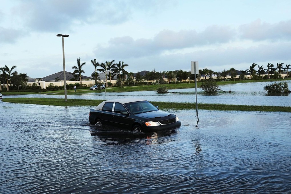 Cars make their away through a flooded street the morning after Hurricane Irma swept through Florida. Photo: AFP