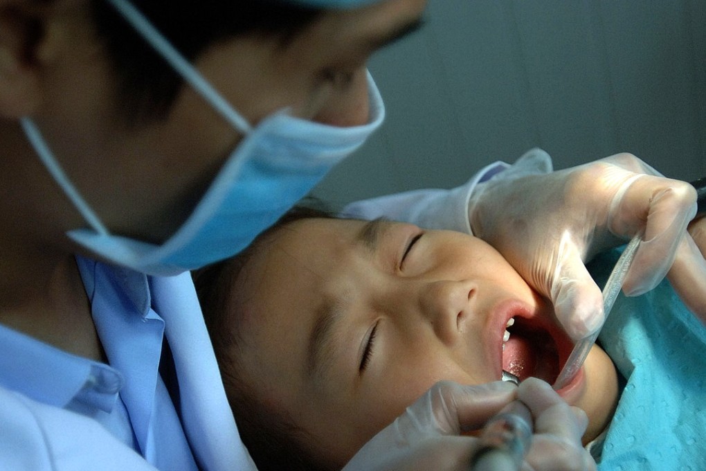 A Chinese dentist examines the mouth of a young patient at one of the first private dental clinics in Hefei, central China's Anhui province, 25 November 2006. Private dental practice in China has been growing dramatically in less than 10 years, to over 35,000 clinics and continuing to rise, with some 100,000 dentists in China, meaning one dentist for every 33,000 people, while in a developed country, the ratio is normally 1 dentist to 4,000 people, and in some countries even 1 to 3,000. Photo: Getty