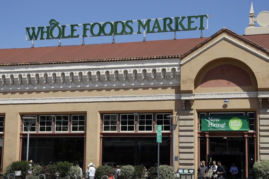 Customers exit a Whole Foods Market in Oakland, California. The splashy price cuts Amazon made as the new owner of Whole Foods boosted online grocery sales. Photo: AP