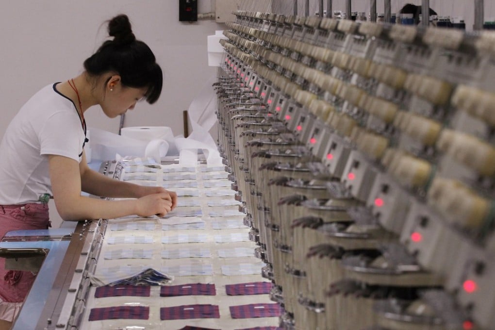 A woman operates an embroidering machine at the TAL factory in Dongguan. The company has invested heavily in new equipment to meet its buyers’ demands and tough environmental regulations. Photo: Handout