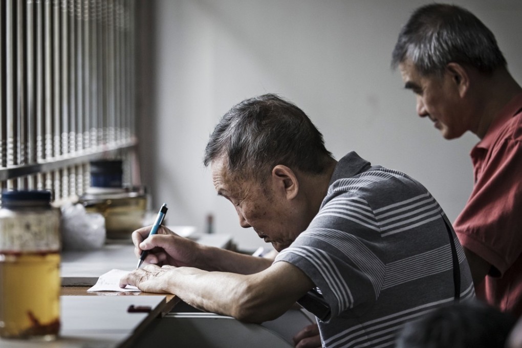 An elderly stock investor sits at a trading terminal at a securities brokerage in Shanghai. Photo: Bloomberg