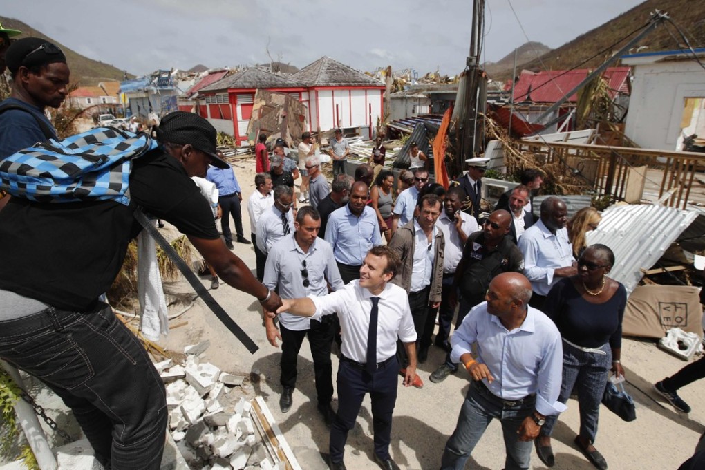 French President Emmanuel Macron (centre) shakes hands with residents during a visit to the French Caribbean island of St Martin on Tuesday. Photo: AFP