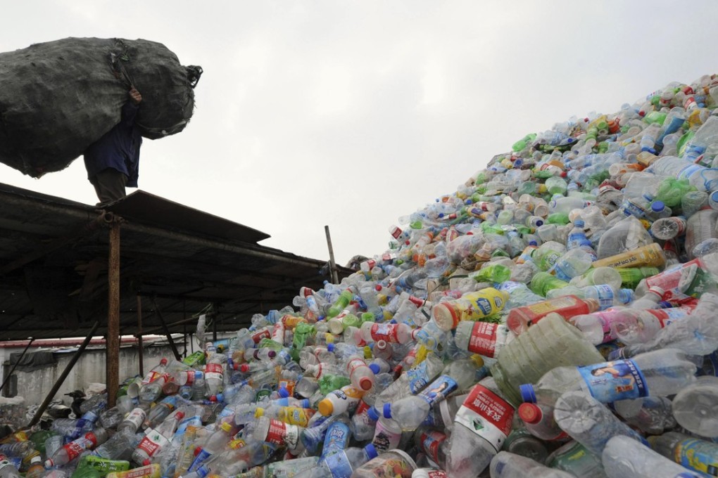 A man carries a bag of plastic bottles on the roof of a recycling centre in Hefei in Anhui province. Photo: Reuters