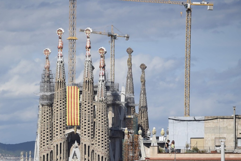 A Senyera flag (Catalan flag) hangs from the “Sagrada Familia” (Holy Family) basilica in Barcelona during the National Day of Catalonia, the “Diada.” The site was evacuated on Tuesday, September 12, because of an anti-terror operation. Photo: AFP