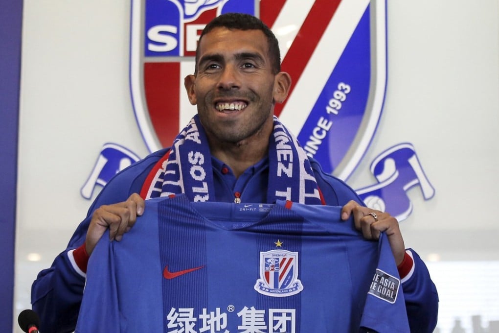 Carlos Tevez posing with the Shanghai Shenhua jersey. Photo: AFP