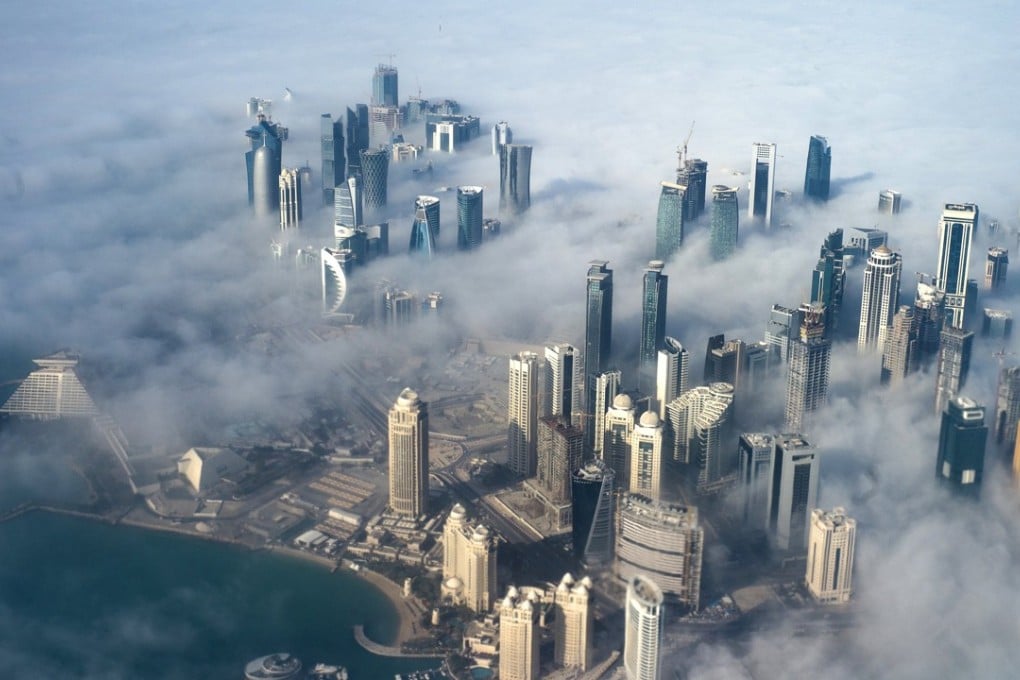 High-rise buildings emerge through fog covering the skyline of Doha, a city where traffic, a lack of pavements for walking and cycle lanes add to daily stresses. Photo: EPA